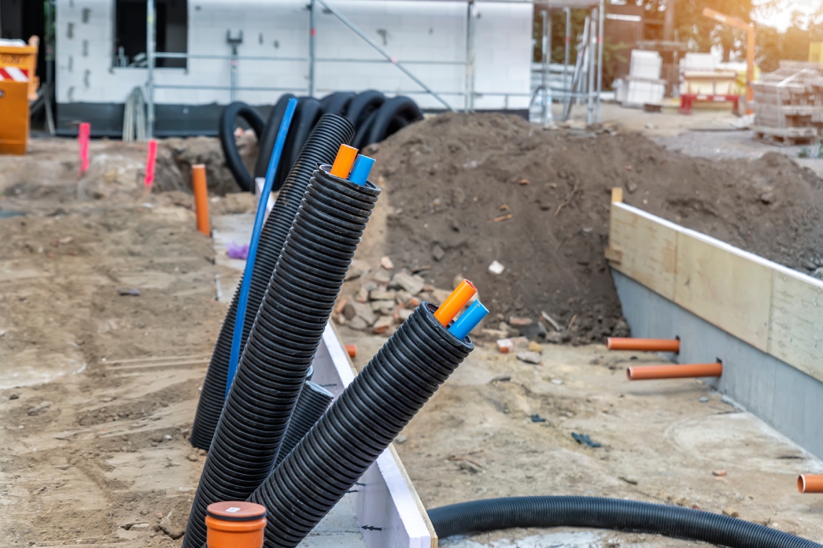 Custom outdoor kitchen construction in New Jersey showing utility conduit and gas line installation.